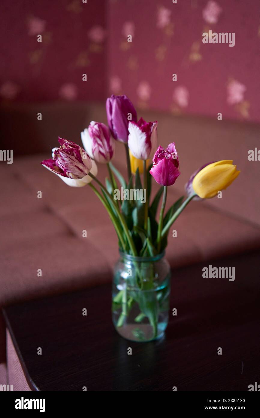 un bouquet de tulipes multicolores dans un bocal transparent à l'intérieur Banque D'Images