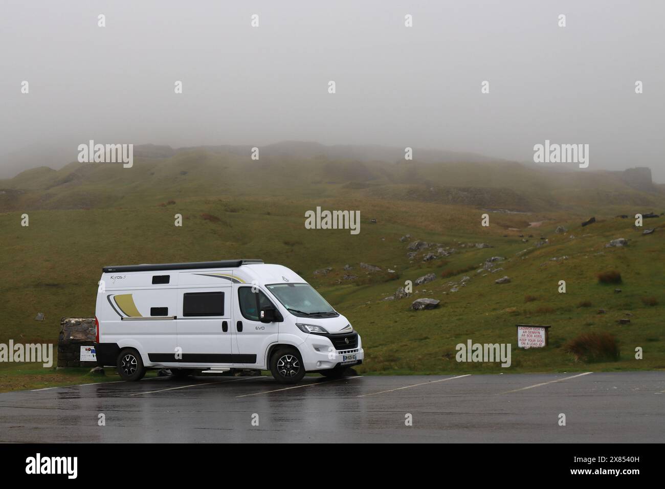Une camionnette blanche solitaire garée dans un parking à flanc de montagne. 27 avril 2024. Une vue depuis les Black Mountains dans le Carmarthenshire, au sud du pays de Galles. Photos prises un matin de bruine fine constante avec une mauvaise visibilité. Banque D'Images