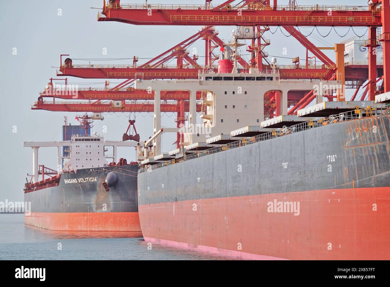 YANTAI, CHINE - 22 MAI 2024 - de grands cargos déchargent du minerai de bauxite importé et du charbon importé dans le port de Yantai, province du Shandong, Chine, le 22 mai Banque D'Images