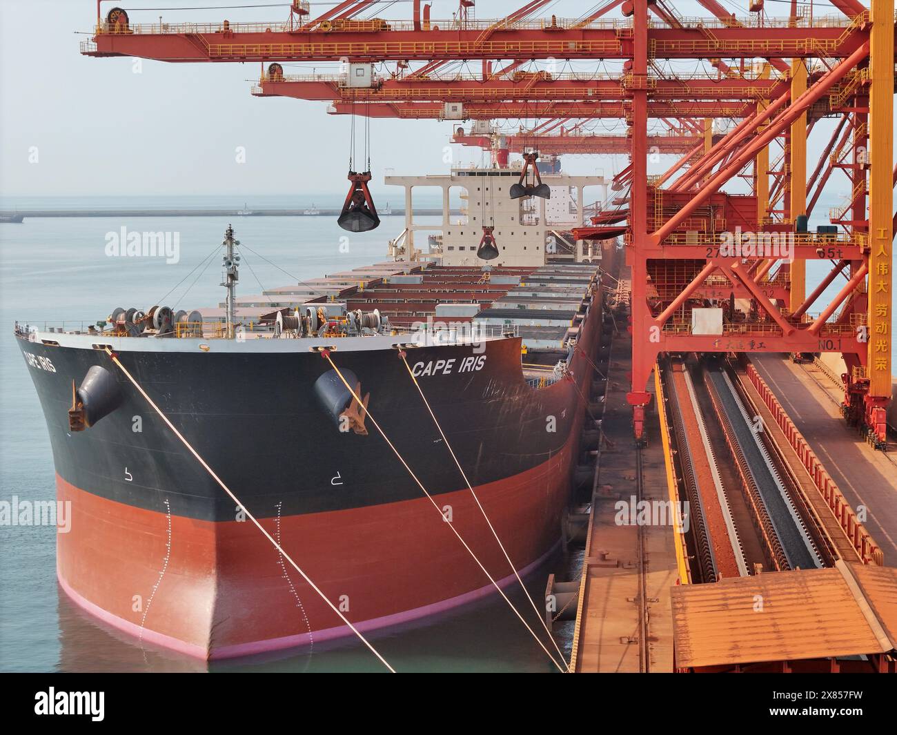 YANTAI, CHINE - 22 MAI 2024 - de grands cargos déchargent du minerai de bauxite importé et du charbon importé dans le port de Yantai, province du Shandong, Chine, le 22 mai Banque D'Images
