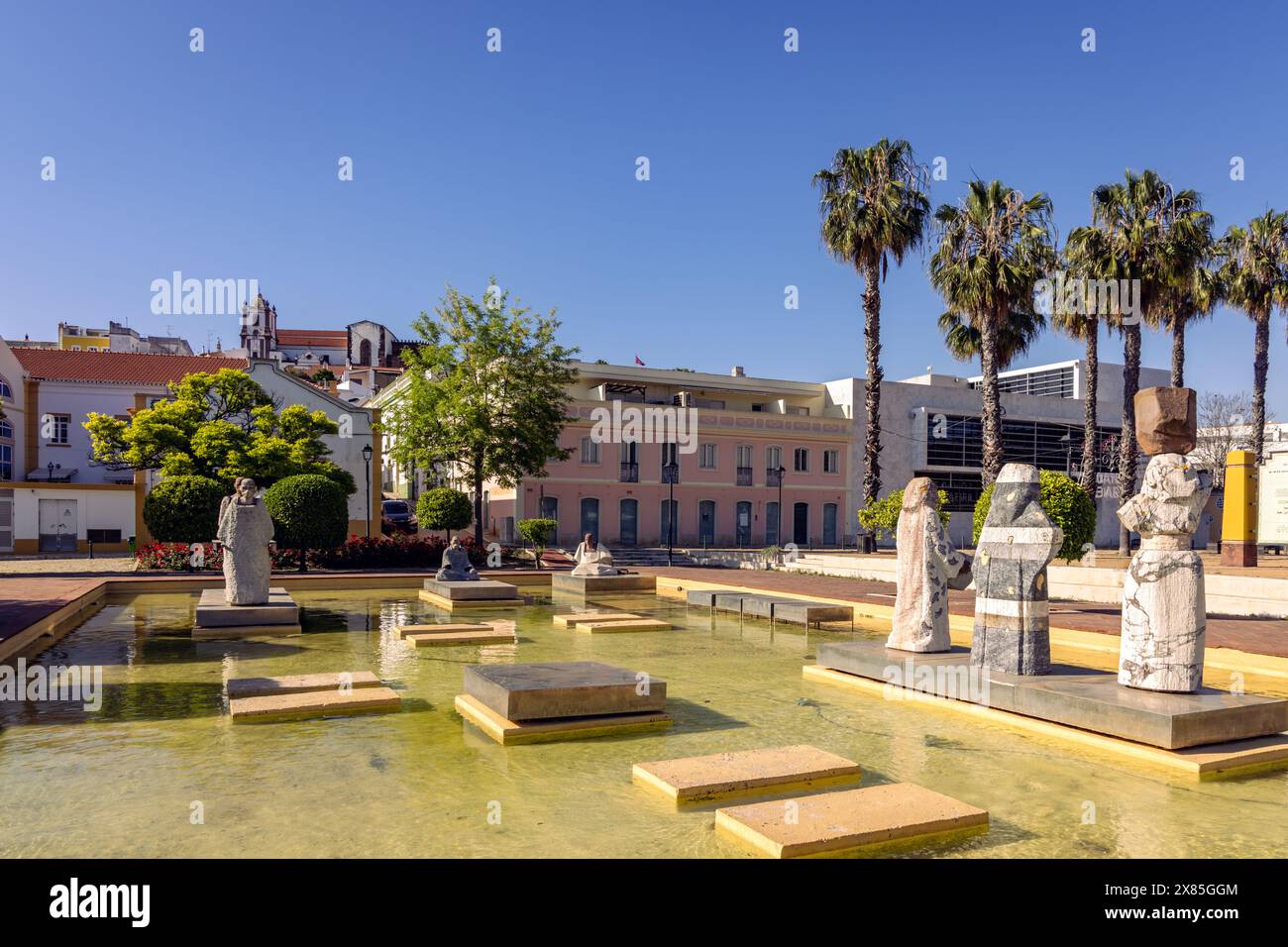 Statues dans une piscine ornementale dans la Praca al Mutamid avec la cathédrale au loin, Silves, Portugal Banque D'Images