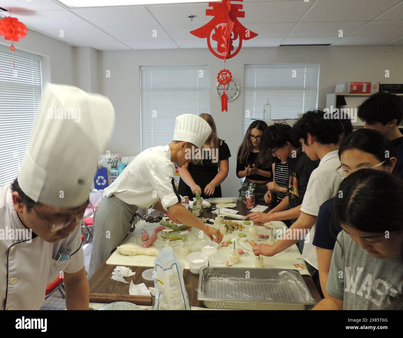 Chicago, États-Unis. 21 mai 2024. Les élèves préparent des pâtisseries lors d’un cours de chinois au Consulat général de Chine à Chicago, aux États-Unis, le 21 mai 2024. Quelque 60 lycéens du district de Chicago public School (CPS) ont vécu une expérience d’immersion dans la culture chinoise mardi lors d’un cours de chinois. POUR ALLER AVEC 'Feature : une classe chinoise incroyable pour les étudiants américains' crédit : lu Shen/Xinhua/Alamy Live News Banque D'Images