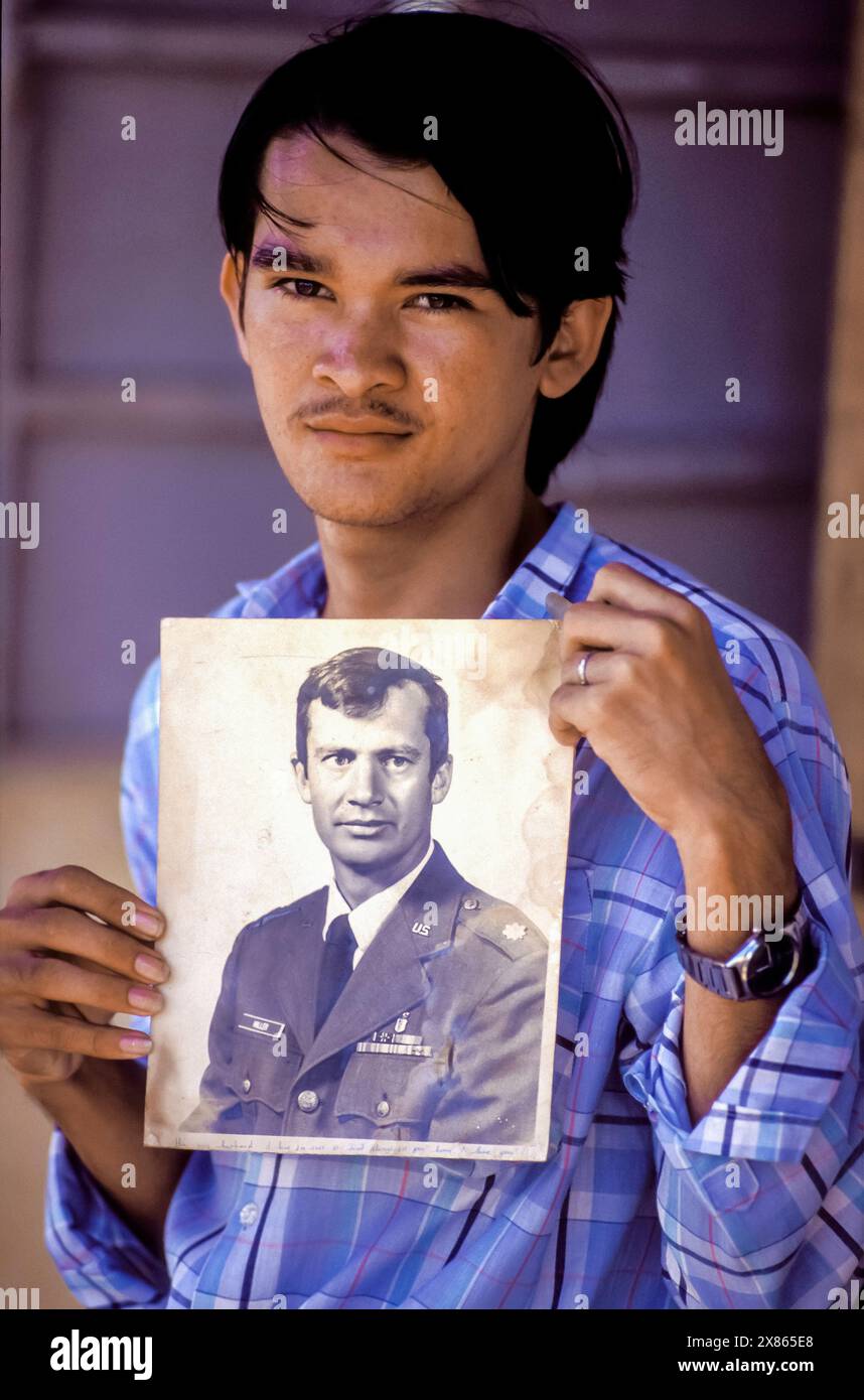 Philippines, Luzon ; garçon réfugié de mère vietnamienne et père américain montrant une photo de son père. Banque D'Images