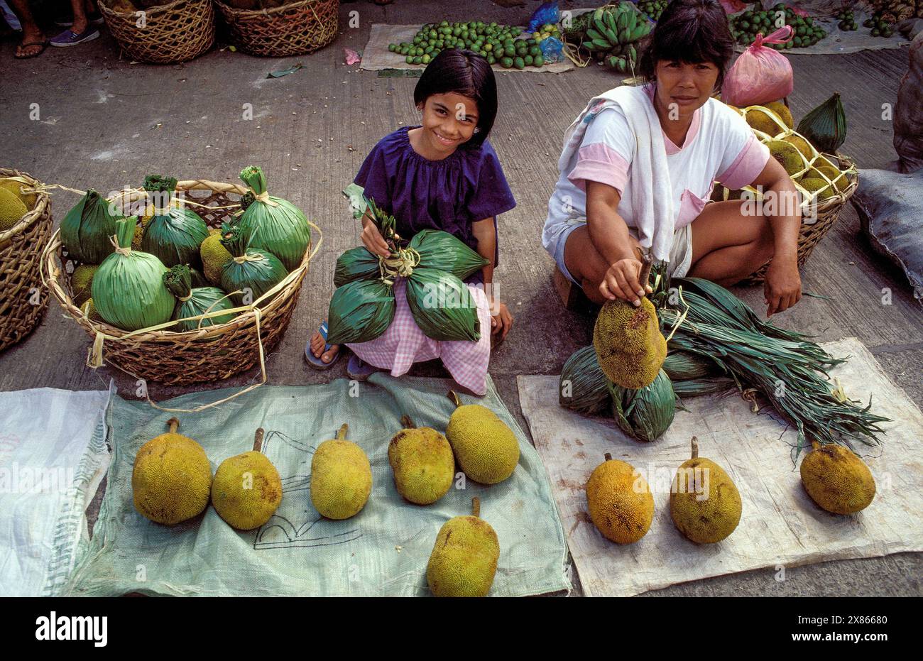 Philippines, Mindanao. Mère et fille vendent des durians à Davao, un fruit tropical. Banque D'Images