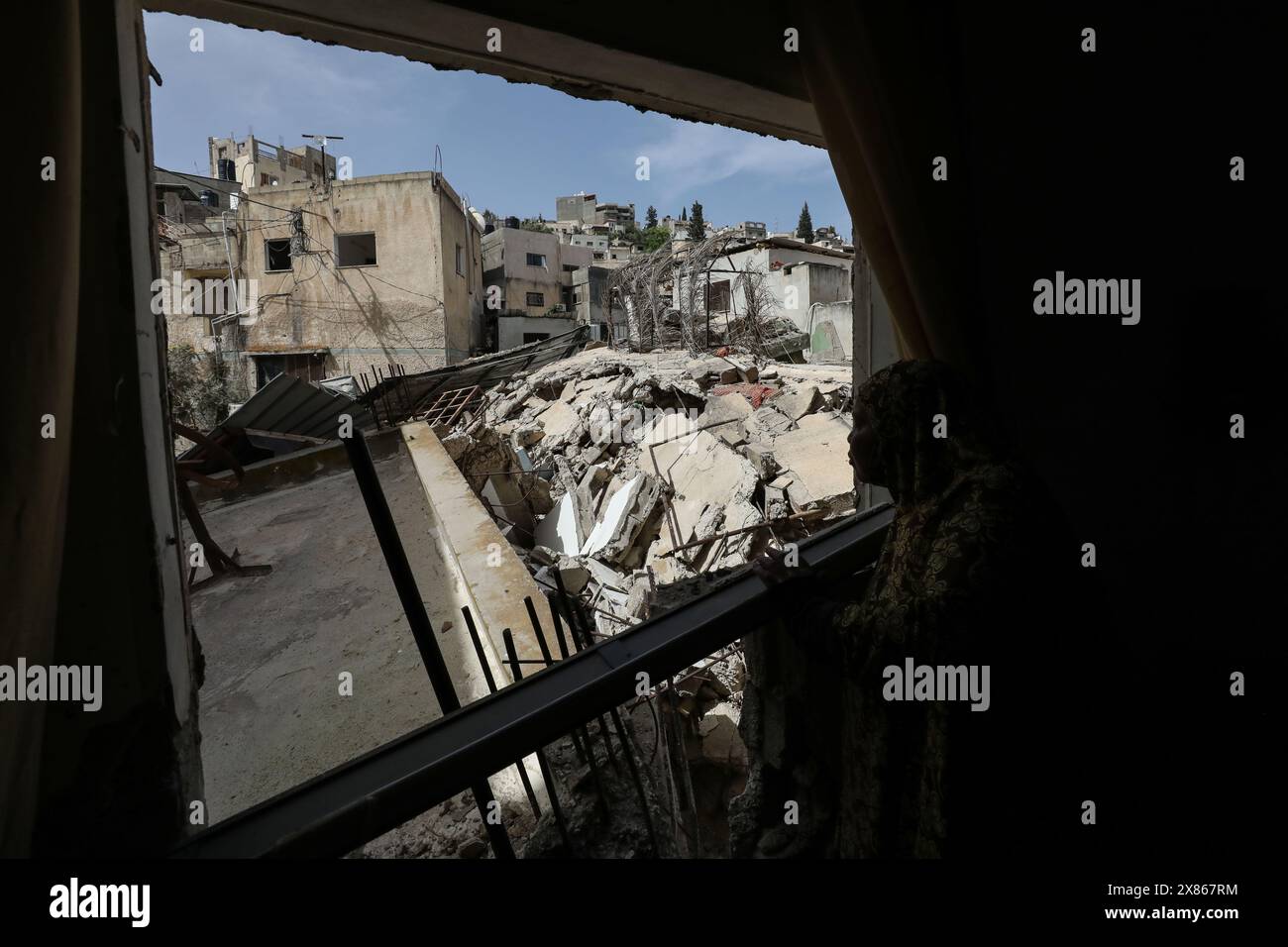 Jenin. 23 mai 2024. Un palestinien vérifie les débris de construction après une opération militaire israélienne dans la ville de Djénine en Cisjordanie, le 23 mai 2024. L'armée israélienne s'est retirée jeudi de Djénine en Cisjordanie et de son camp de réfugiés après trois jours d'opération militaire, tuant 12 Palestiniens et en blessant 25 autres, ont déclaré des sources sécuritaires palestiniennes. Des sources sécuritaires palestiniennes ont déclaré à Xinhua que les forces israéliennes avaient pris d'assaut la ville de Djénine et son camp mardi matin. Crédit : Nidal Eshtayeh/Xinhua/Alamy Live News Banque D'Images