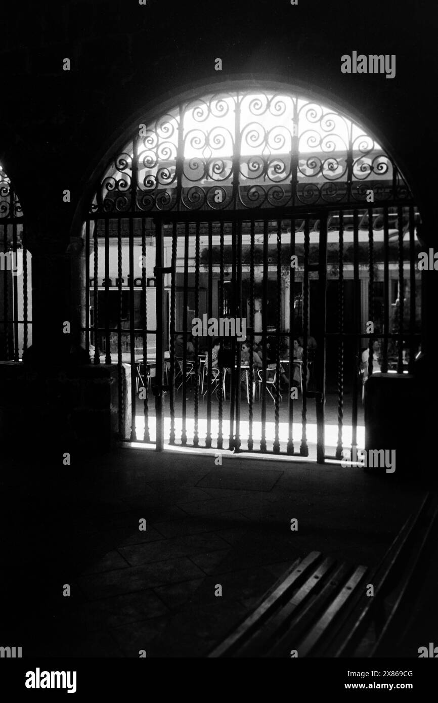 Schmiedeeisernes Gitter im Gegenlicht in der Altstadt von Perpignan, Frankreich 1957. Grille en fer forgé rétroéclairée dans le centre historique de Perpignan, France 1957. Banque D'Images
