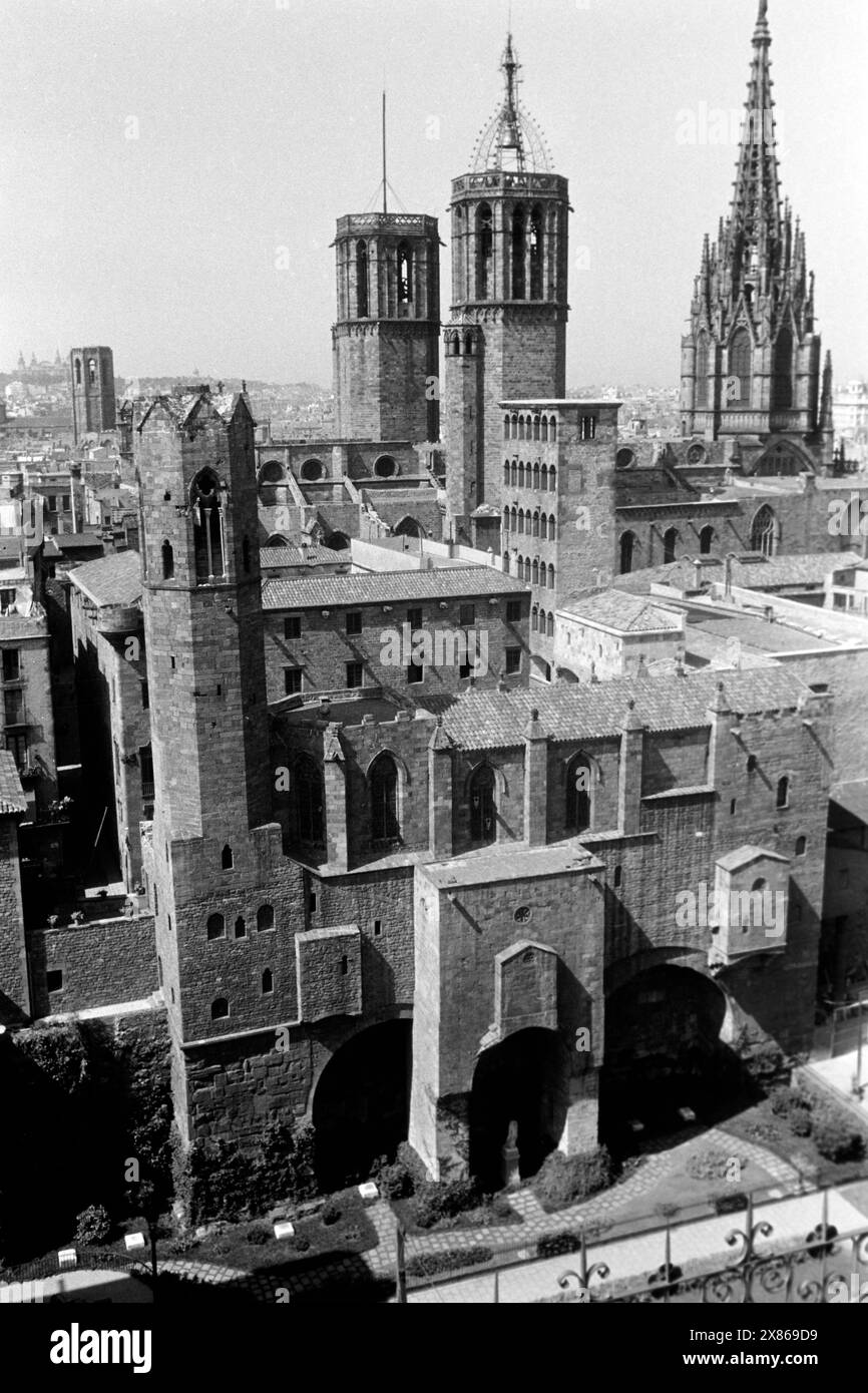 Die drei Türme der Kathedrale von Barcelona, der hintere rechte trägt den eisernen Glockenkäfig mit Glocke, mittig die vielen Fenster des Aussichtsturms des Rey Martín sowie links der Turm des Palacio Real, Spanien 1957. Les trois tours de la cathédrale de Barcelone, la tour arrière à droite porte la cage de fer avec cloche, au centre les nombreuses fenêtres de la tour d'observation Rey Martín et à gauche la tour du Palacio Real, Espagne 1957. Banque D'Images