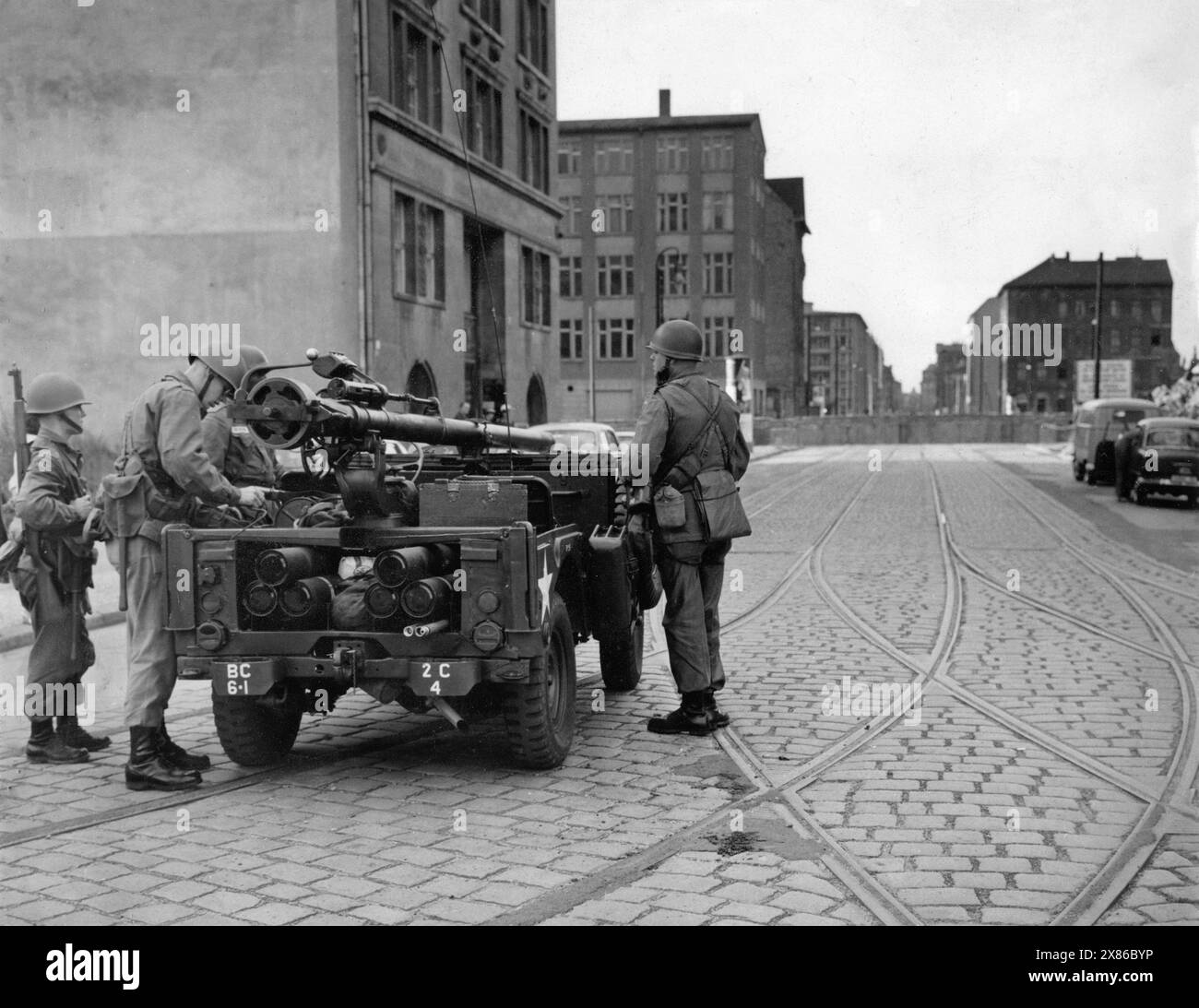 US-Soldaten richten eine Kurzschusswaffe auf einem Jeep in Richtung der kürzlich errichtete Berliner Mauer aus, Berlin 1961.- originale Bildbeschreibung : 'Mitten durch die Hauptstadt führt die Grenze der beiden Machtblöcke - OST : WEST - mit Betonmauern, Stacheldraht und Bajonetten der Volkspolizei wächst die Mauer zwischen Ost und West, und zwar nicht nur in Berlin.' - Hanschriftlich ergänzt : Amerikaner in der Charlottenstr. Banque D'Images