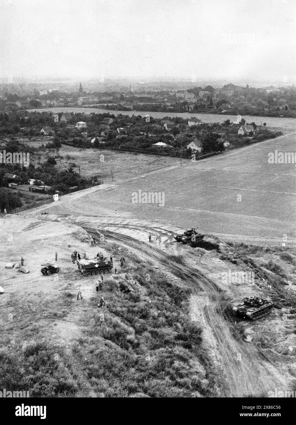 Panzer des US-Army auf einem Feld à Rudow, Berlin 1961. Originale Bildbeschreibung : 'LUFTAUFNAHMEN ! ! ! ! Zur Fernsehsendung AM 27.8. Von 18,05 - 18,55 Uhr : DIE MAUER von Matthias Walden - die sich mit den Auswirkungen der Ereignisse AM 13. August D.J. befasst. - u.b.z. : amerikanischer Panzer geht an der Zonengrenage in Rudow in Stellung' Banque D'Images