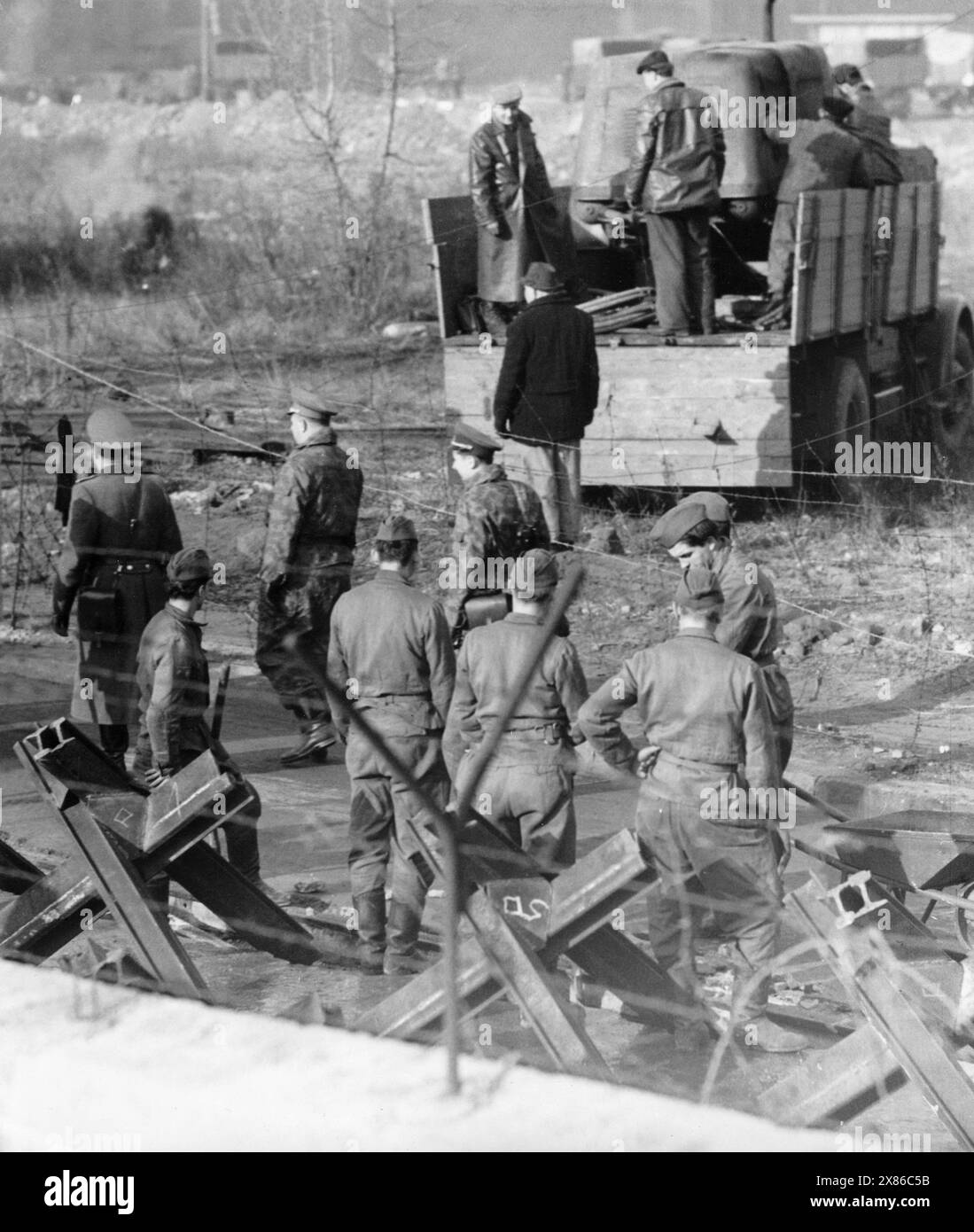 Bauarbeiten zum Ausbau der Berliner Mauer auf Ostseite am Checkpoint Charlie, Berlin 1961. - Originale Bildbeschreibung : 'Spanische Reiter, Panzersperren, Laufgräben und Steinwälle gehen durch Deutschlands Hauptstadt BERLIN' - Seit den gestrigen Abendstunden sind mehrere tausend Menschen - wohnhaft : Ost-Berlin - damit beschäftigt, die seit dem 13. August quer durch Berlin gehende Mauer weiter zu verstärken und auszubauen. Tarnnetze und Laufgräben, Panzersperren und Spanische Reiter versinnbildlichen auf's Anschaulichste die 'Deutsche Demokratische Republik' bezw. Den 'Freien Sektor Berlins'. - Banque D'Images