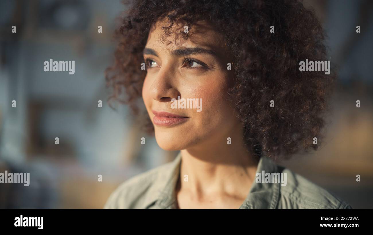 Gros plan Portrait d'une Brunette multiethnique à la peau foncée aux cheveux bouclés et aux yeux bruns. Joyeuse jeune femme créative regardant la caméra et souriant charmante. Banque D'Images