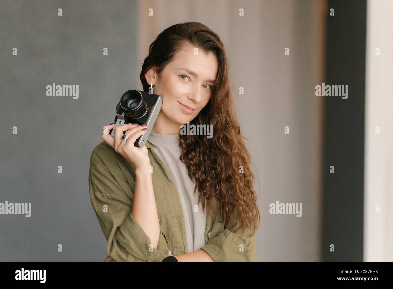 Femme souriante avec caméra dans une nouvelle maison Banque D'Images