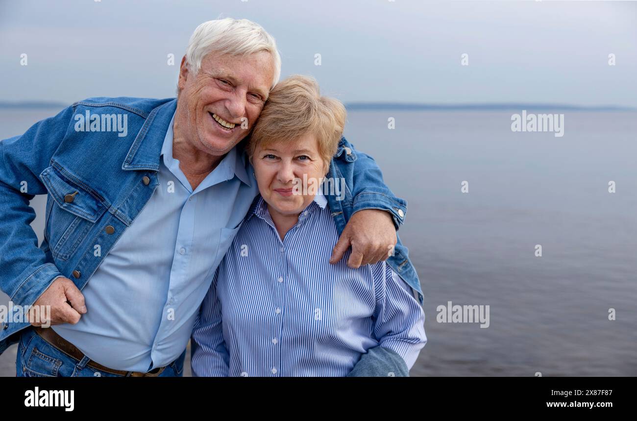 Heureux couple senior debout près de la mer à la plage Banque D'Images