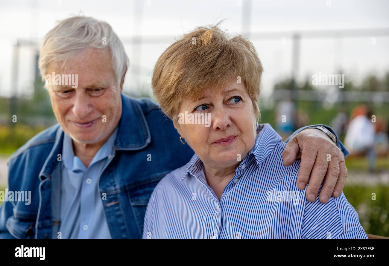 Homme senior avec bras autour de la femme au parc Banque D'Images
