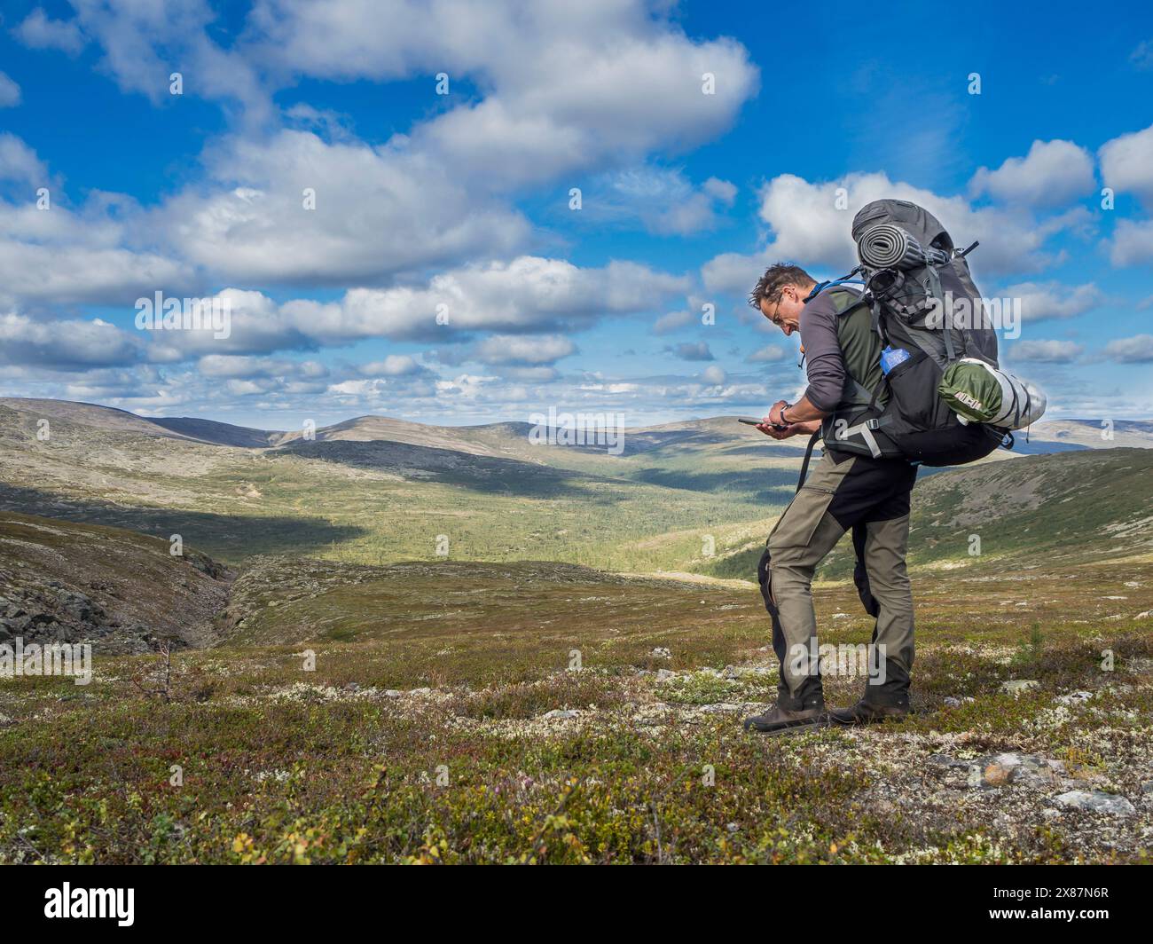 Finlande, Laponie, Hiker vérifier le téléphone dans le parc national Urho Kekkonen Banque D'Images