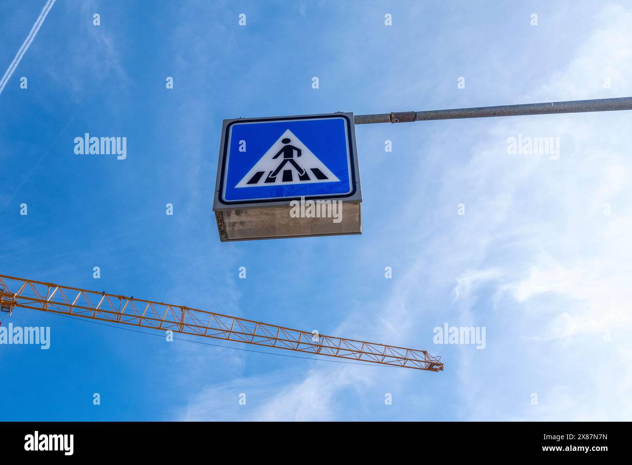 Allemagne, Bavière, Munich, vue en angle bas du panneau de passage pour piétons et grue industrielle contre le ciel Banque D'Images