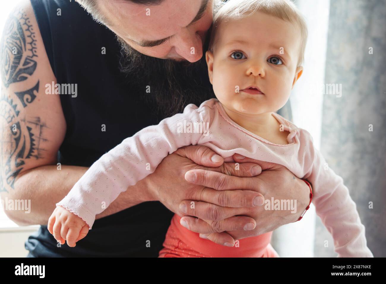 Père embrassant la fille avec les mains entrelacées à la maison Banque D'Images Père embrassant la fille avec les mains entrelacées à la maison Banque D'Images