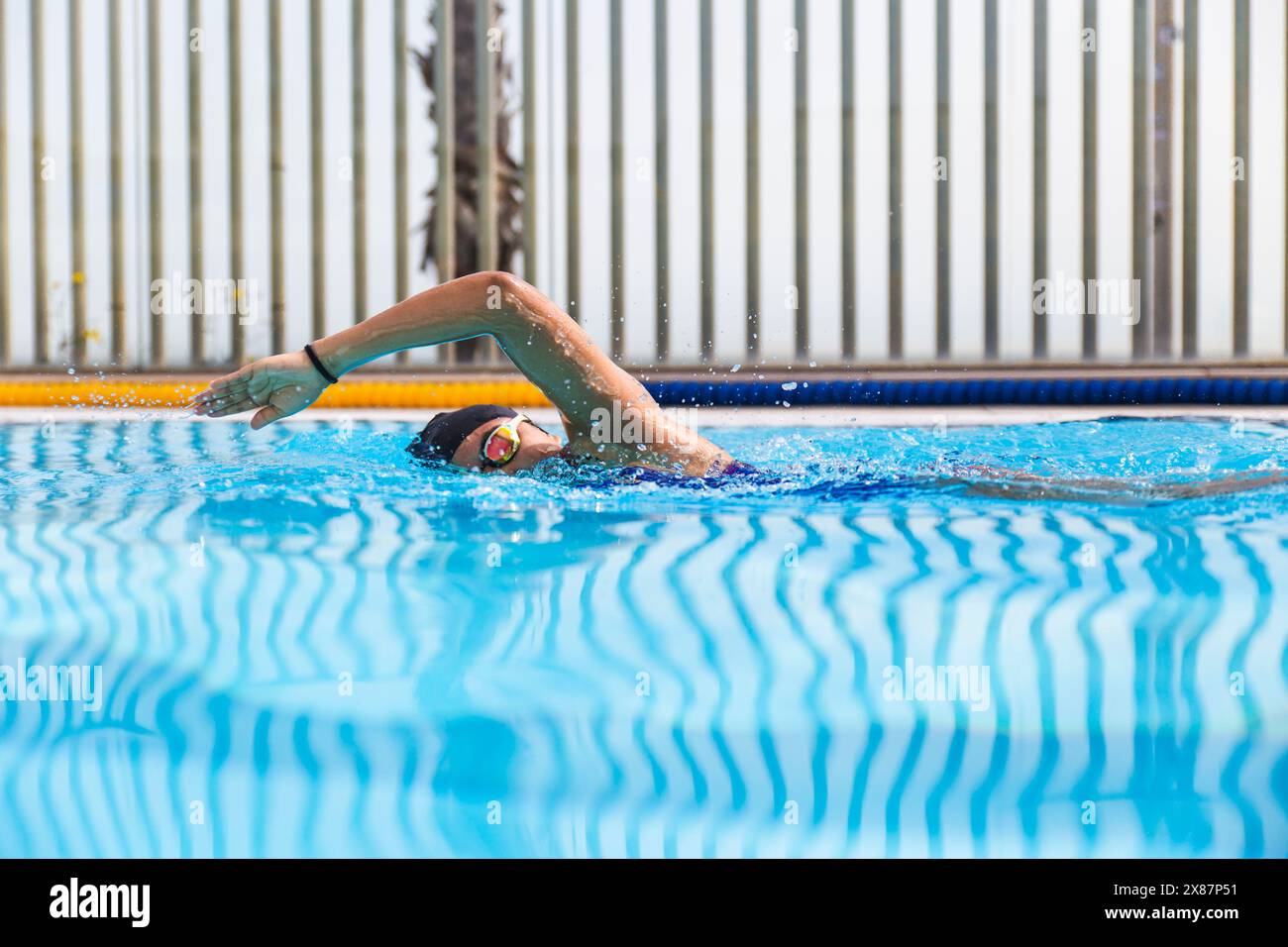 Femme nageant dans la piscine par beau temps Banque D'Images