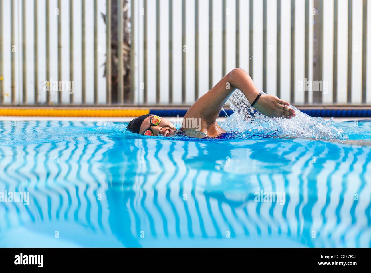 Jeune femme nageant dans l'eau un jour ensoleillé Banque D'Images Jeune femme nageant dans l'eau un jour ensoleillé Banque D'Images