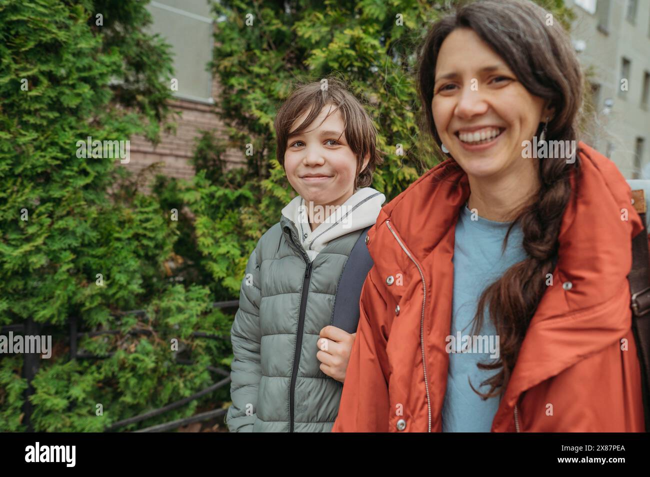 Heureuse mère et fils adolescent marchant dans la rue Banque D'Images Heureuse mère et fils adolescent marchant dans la rue Banque D'Images