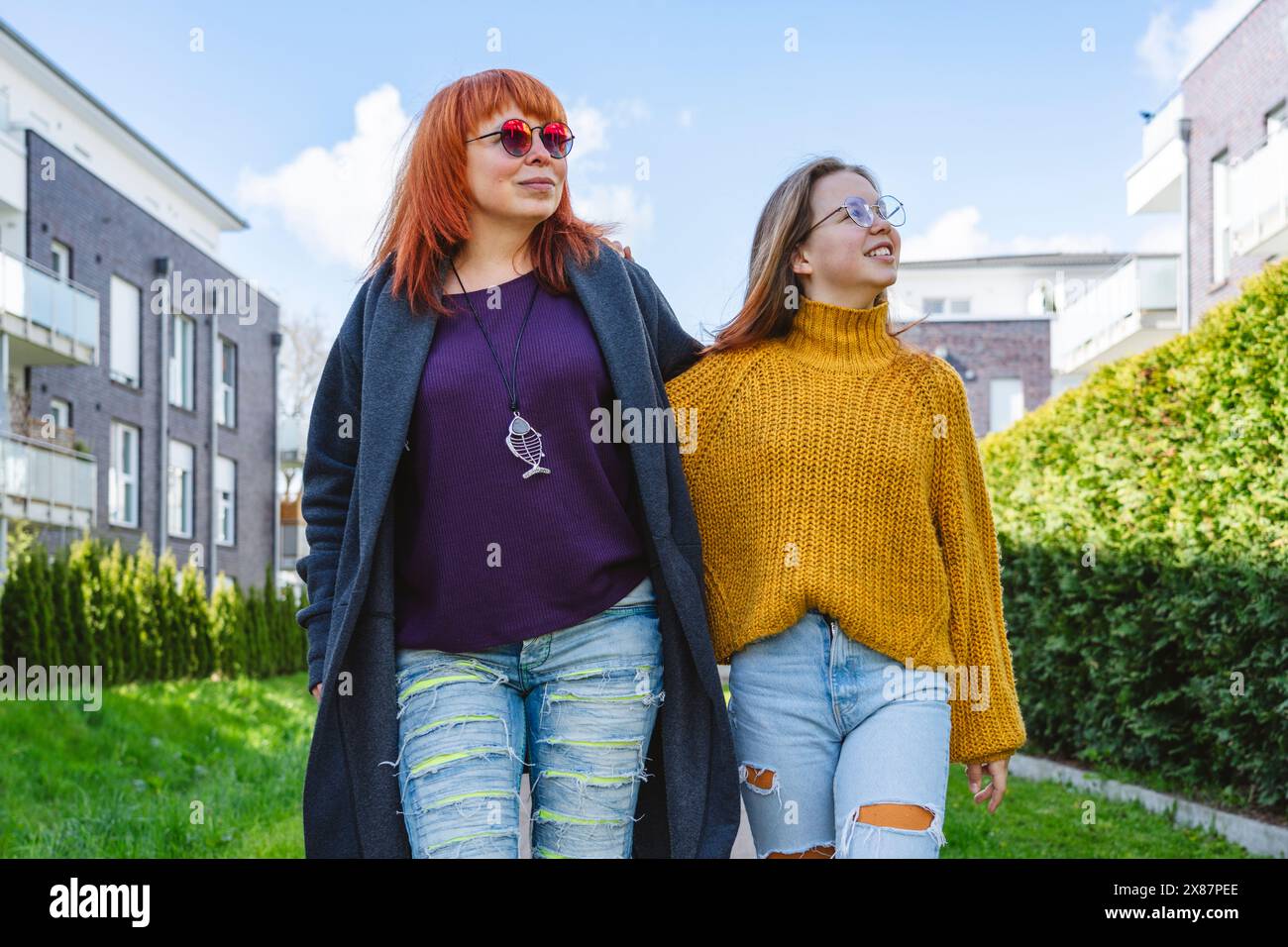 Mère et fille souriantes marchant dans le jardin Banque D'Images Mère et fille souriantes marchant dans le jardin Banque D'Images