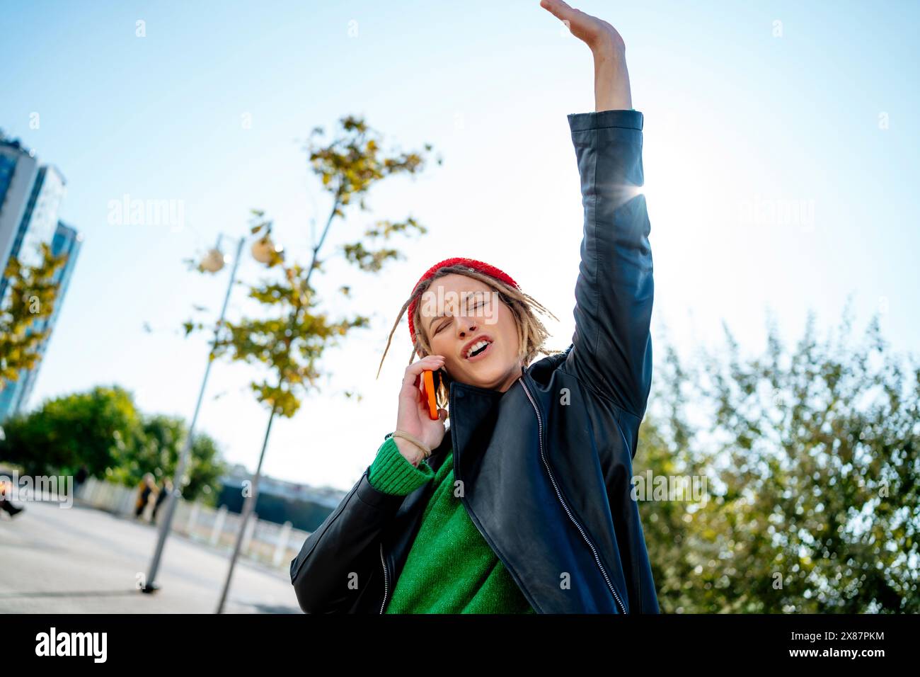 Jeune femme parlant sur téléphone intelligent avec la main levée Banque D'Images Jeune femme parlant sur téléphone intelligent avec la main levée Banque D'Images