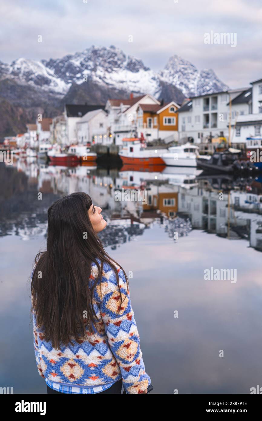 Norvège, Nord de la Norvège, Henningsvaer, dos de brune à cheveux longs debout sur la côte du village de pêcheurs dans l'archipel des Lofoten Banque D'Images Norvège, Nord de la Norvège, Henningsvaer, dos de brune à cheveux longs debout sur la côte du village de pêcheurs dans l'archipel des Lofoten Banque D'Images