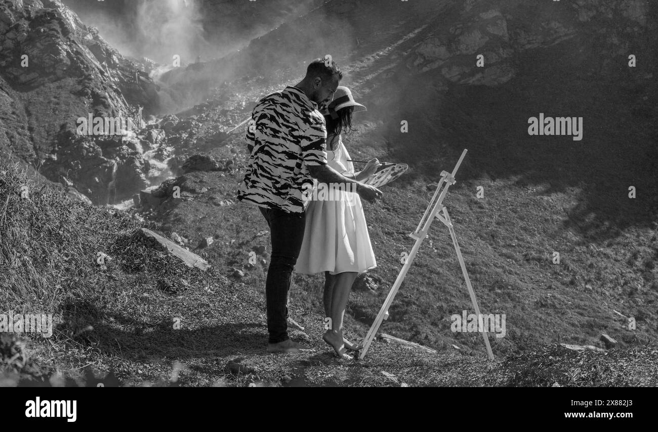 Aimer jeune couple ensemble sur fond de nature. Couple d'artistes amoureux du dessin dans les montagnes. Plan extérieur d'un jeune couple peindre une image dedans Banque D'Images