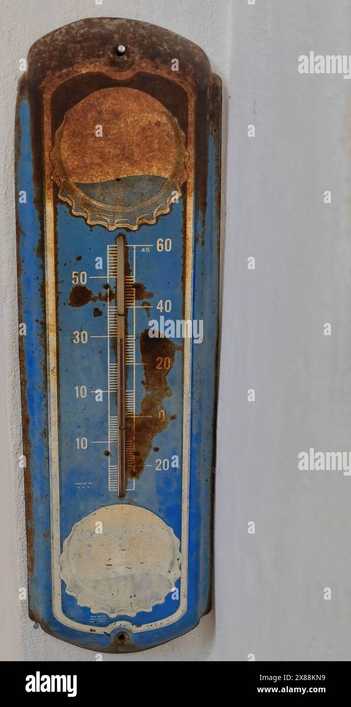Thermomètre mural vintage 318 rouillé à l'échelle Celsius, marchandise de marque avec un logo délavé, souvenirs conservés dans le Revolution Cafe. Santa Clara-Cuba. Banque D'Images