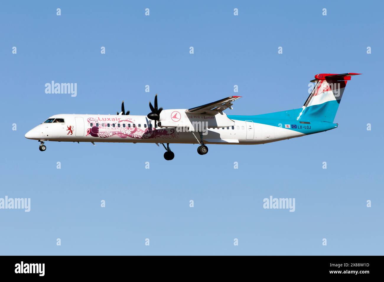 Barcelone, Espagne. 23 décembre 2023. Un Luxair - Luxembourg Airlines Bombardier Dash 8-Q402 sponsorisant l'organisation à but non lucratif Think Pink, ici vu sur le point d'atterrir à l'aéroport de Barcelone El Prat. Think Pink est une organisation luxembourgeoise à but non lucratif qui soutient les femmes vivant au Luxembourg avec la réalité du cancer, collecte de fonds, création d’événements, soutien aux femmes, etc. (Photo de Fabrizio Gandolfo/SOPA images/SIPA USA) crédit : SIPA USA/Alamy Live News Banque D'Images