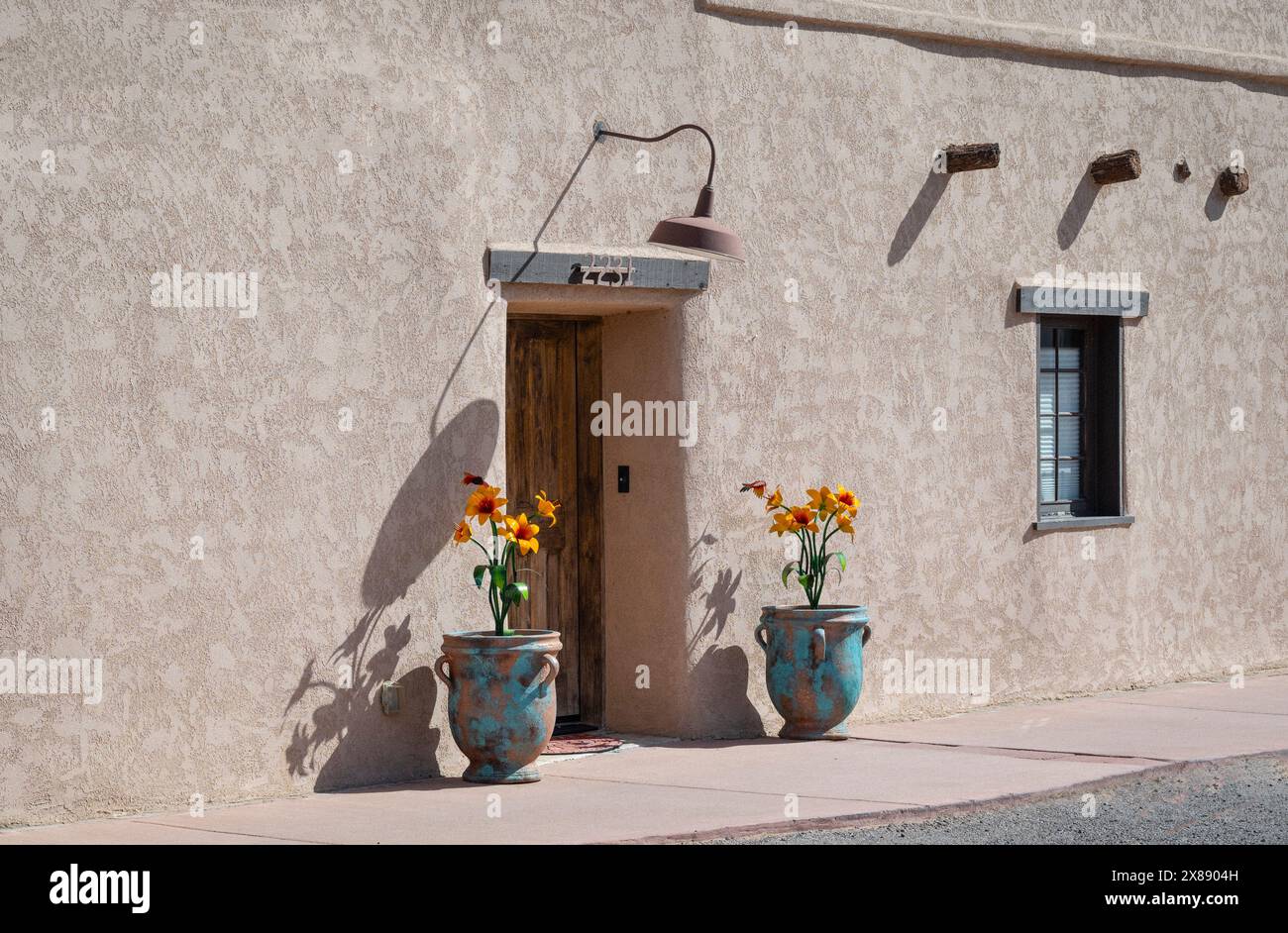 Entrée à Une habitation de style néo-mexicain avec des pots de jardinage turquoise avec une patine lourde affichant des fleurs pop art en métal à Las Cruces, NM, États-Unis Banque D'Images