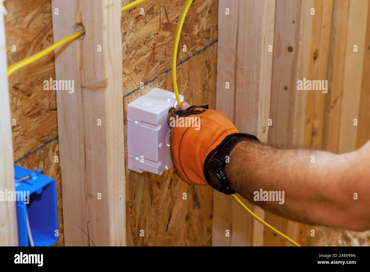 Le câblage électrique du bâtiment nouvellement construit est connecté à la boîte de prise par un électricien Banque D'Images