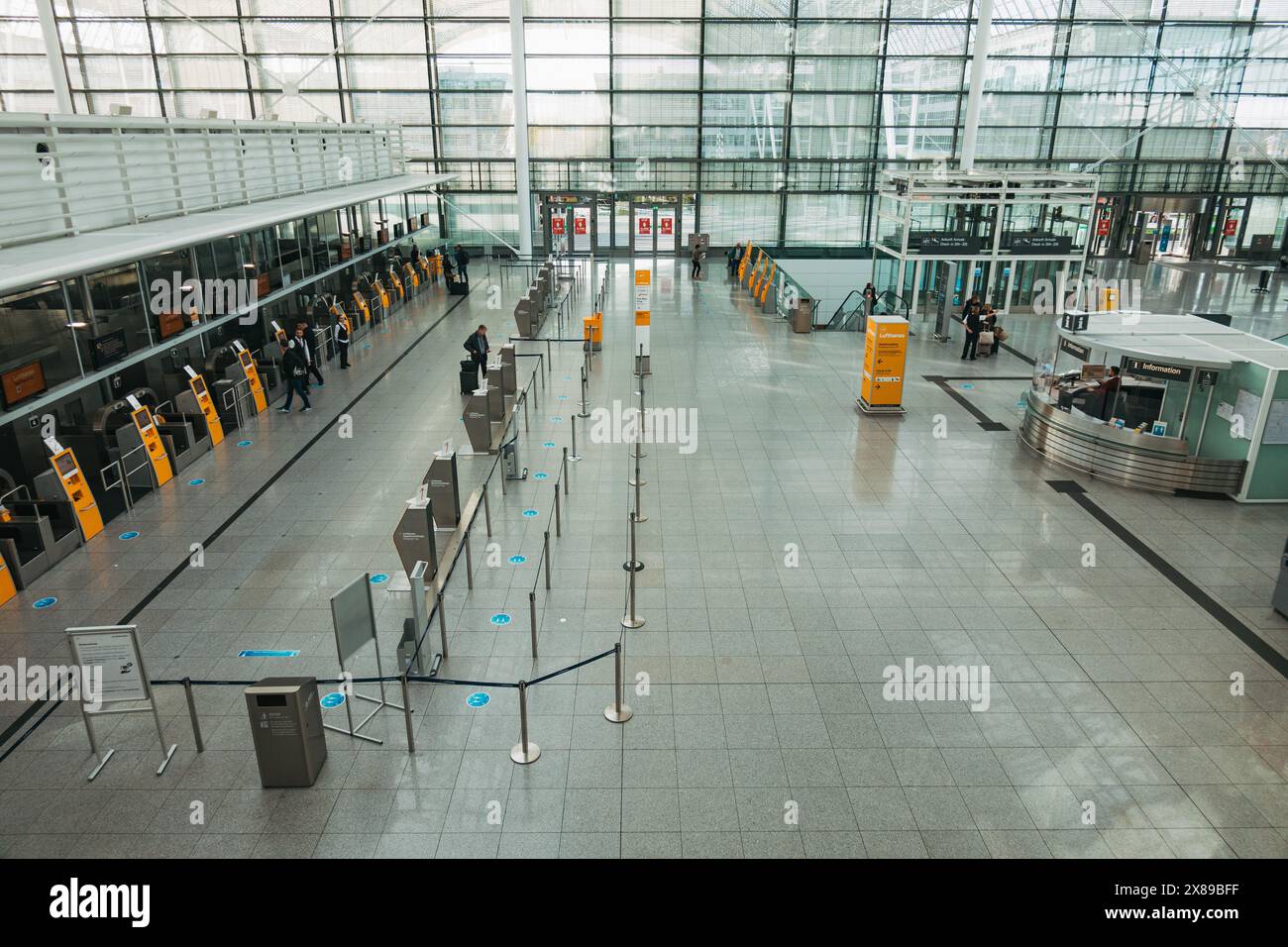 Une zone d'enregistrement vide dans le terminal 2 de l'aéroport international de Munich, en Allemagne, par un après-midi calme. Les murs des fenêtres laissent entrer beaucoup de lumière naturelle Banque D'Images