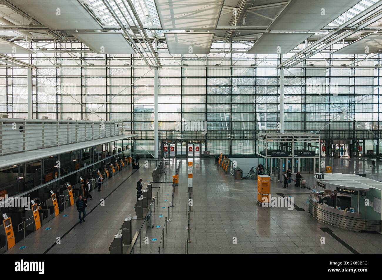Une zone d'enregistrement vide dans le terminal 2 de l'aéroport international de Munich, en Allemagne, par un après-midi calme. Les murs des fenêtres laissent entrer beaucoup de lumière naturelle Banque D'Images