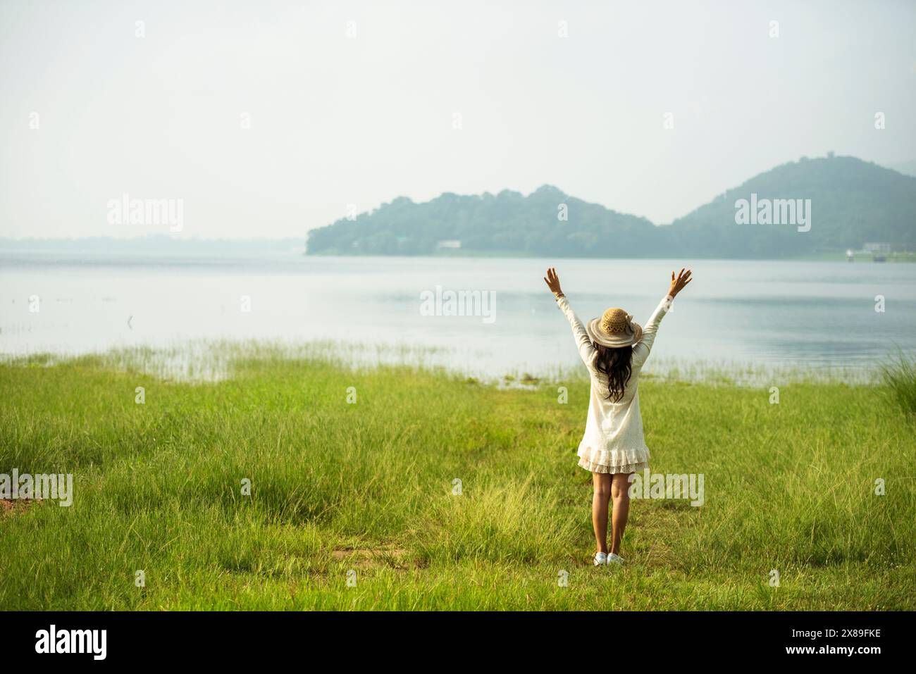 Dos femme sentant la liberté fraîche énergie positive herbe debout champ fleur prairie journée internationale de la femme 8 mars. Relaxatio matinale joyeuse Banque D'Images