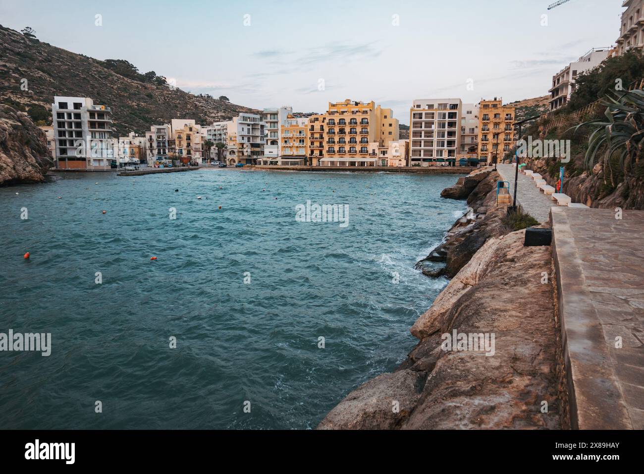 Appartements et un chemin carrelé de pierre ligne Xlendi Bay dans le quartier de Munxar, sur l'île de Gozo, Malte Banque D'Images