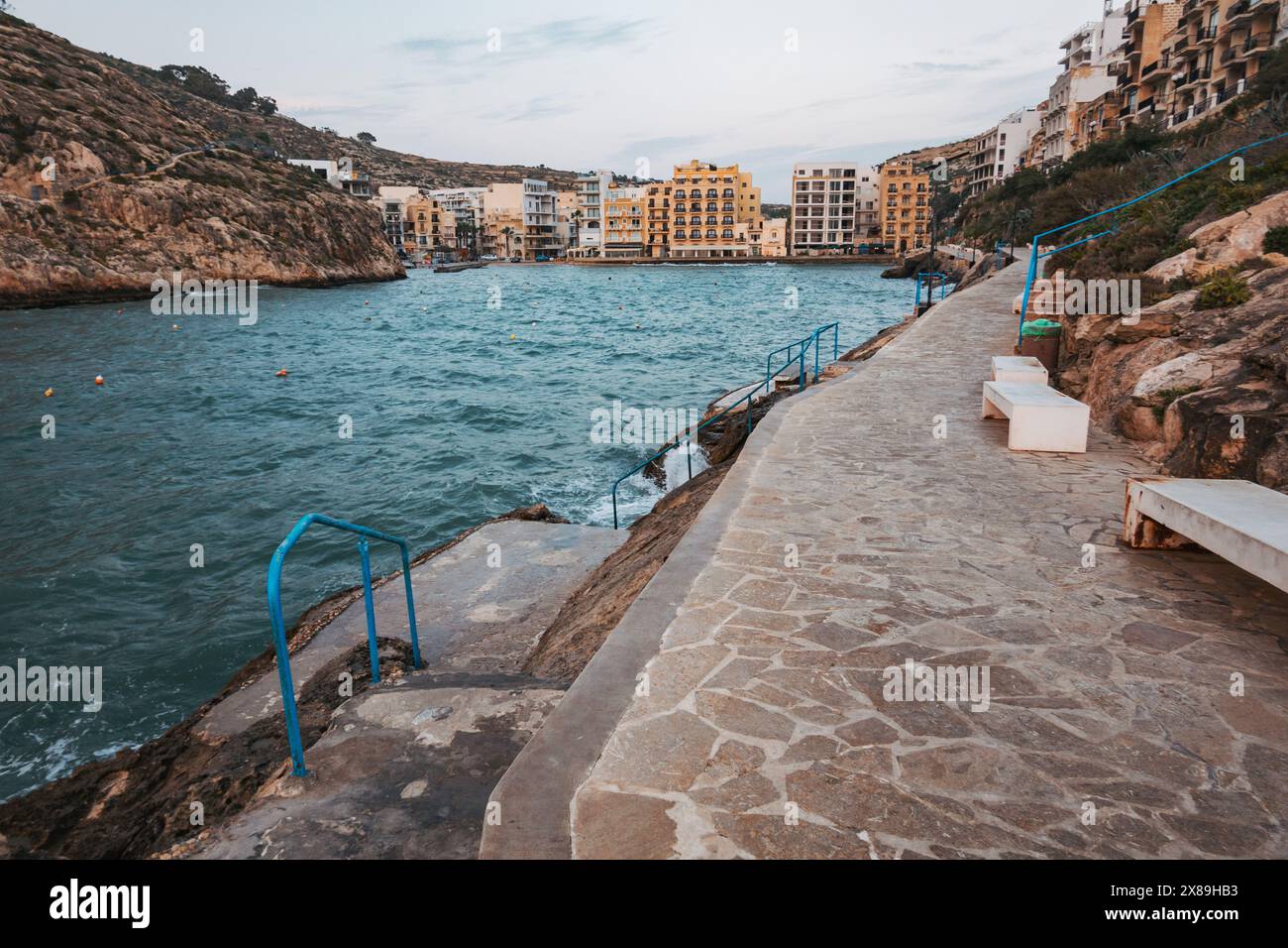 Appartements et un chemin carrelé de pierre ligne Xlendi Bay dans le quartier de Munxar, sur l'île de Gozo, Malte Banque D'Images