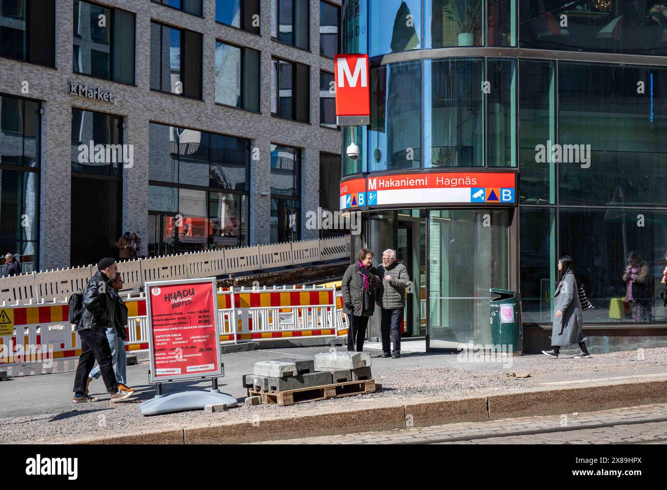 Les gens autour de l'entrée de la station de métro Hakaniemi à l'immeuble de bureaux Lyyra dans le district de Kallio à Helsinki, Finlande Banque D'Images Les gens autour de l'entrée de la station de métro Hakaniemi à l'immeuble de bureaux Lyyra dans le district de Kallio à Helsinki, Finlande Banque D'Images