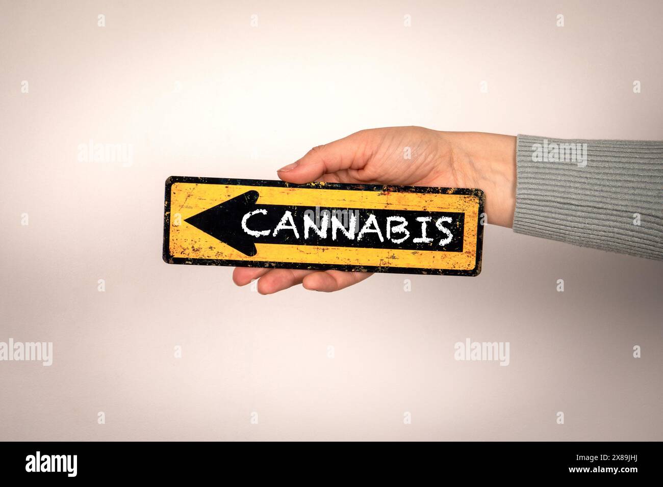 Cannabis. Flèche avec texte dans la main de la femme sur fond blanc. Banque D'Images