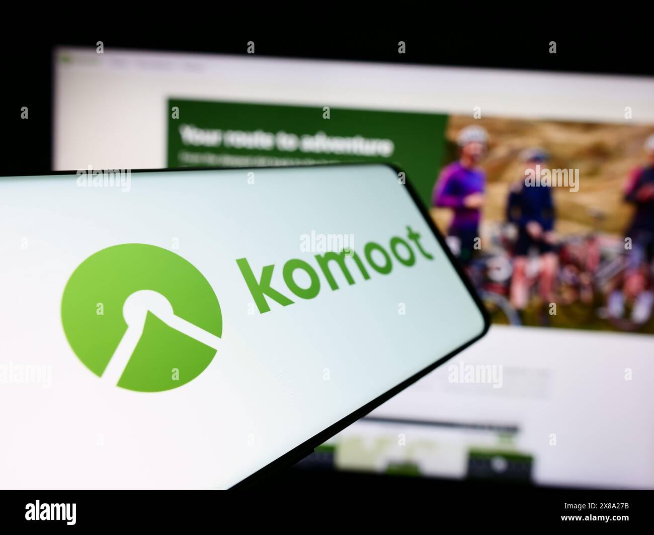 Téléphone portable avec le logo de la société allemande de planification d'itinéraire APP komoot GmbH en face du site Web de l'entreprise. Mettez l'accent sur le centre-gauche de l'écran du téléphone. Banque D'Images