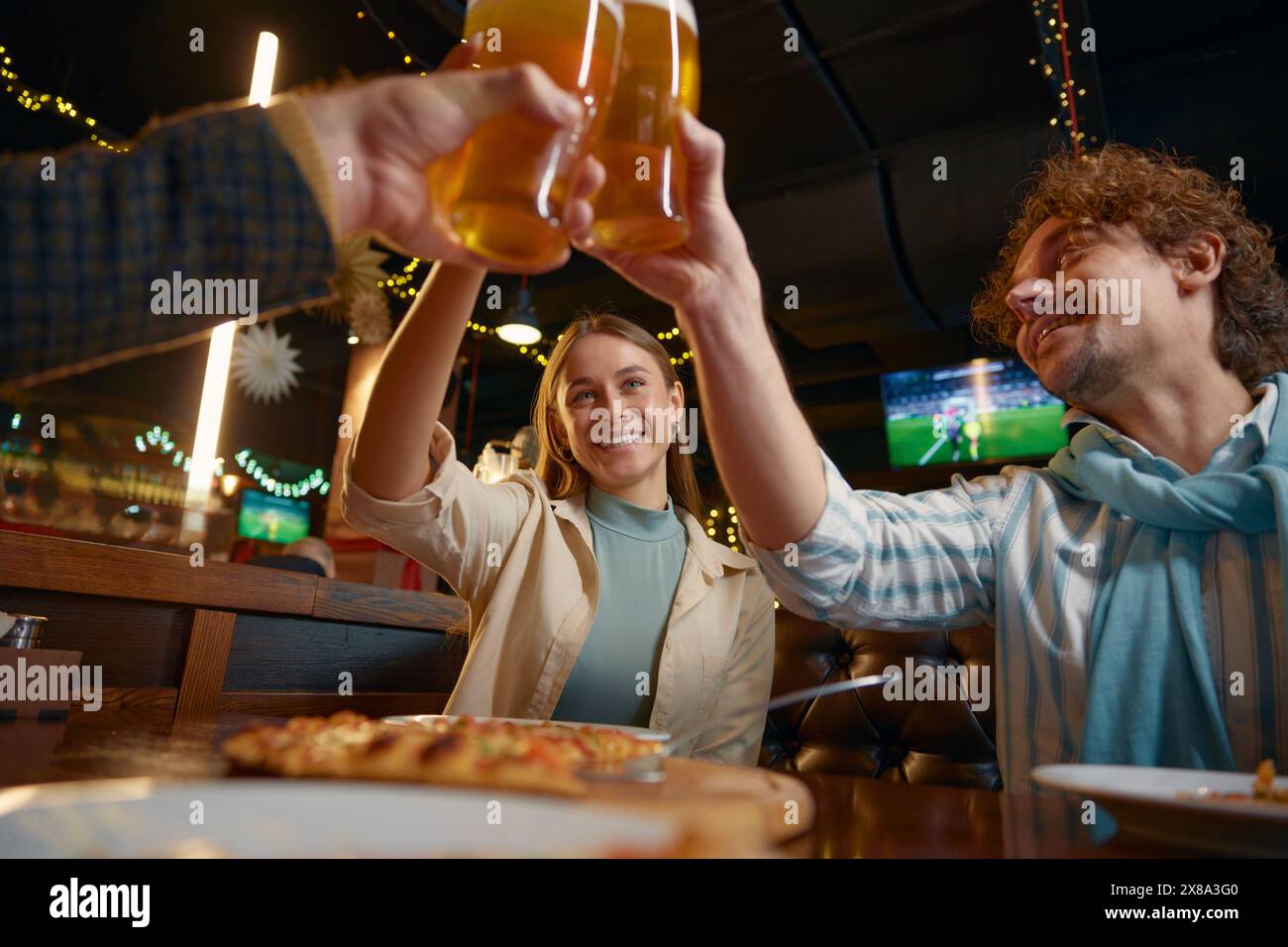 Amis buvant de la bière célébrant la fin de la semaine de travail se reposant dans un pub Banque D'Images