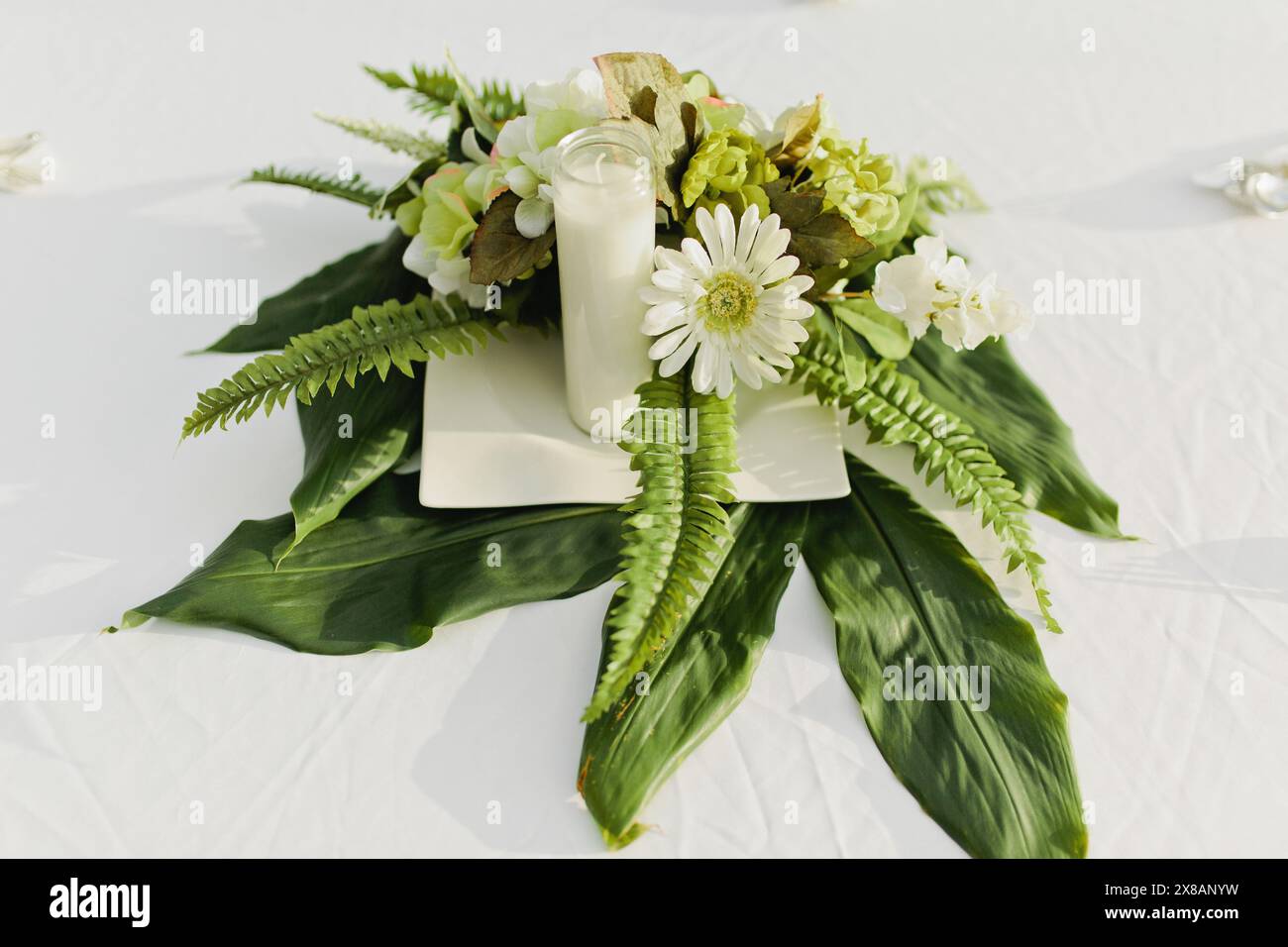 Décoration de table de fleurs blanches avec fougères et verdure Banque D'Images