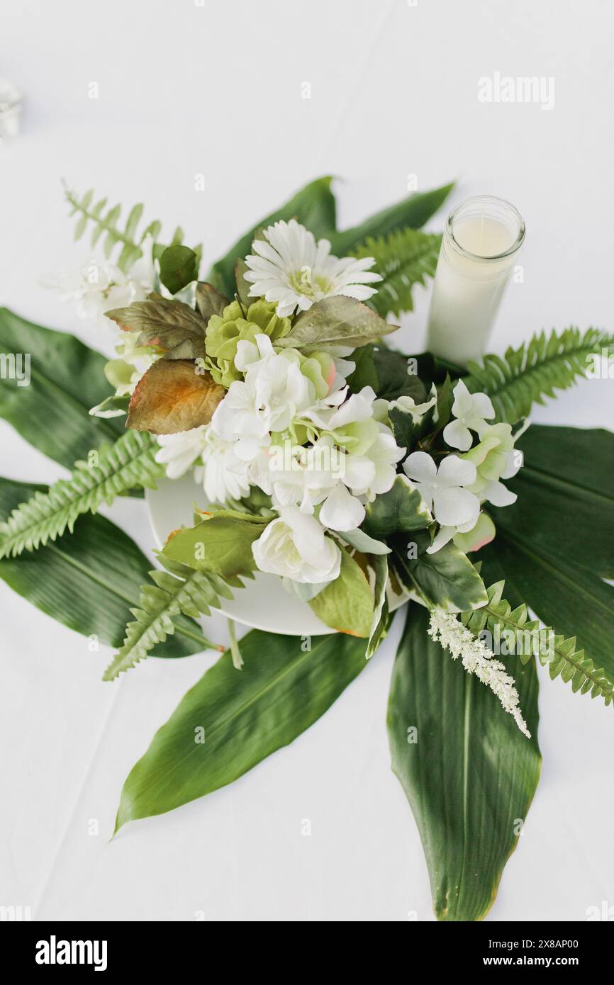 Décoration de table de fleurs blanches avec fougères et verdure Banque D'Images