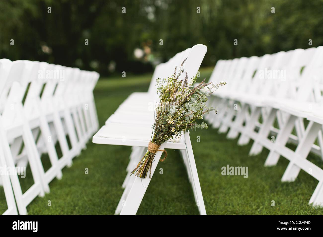 Chaises pliantes blanches décorées de fleurs sauvages et d'eucalyptus Banque D'Images