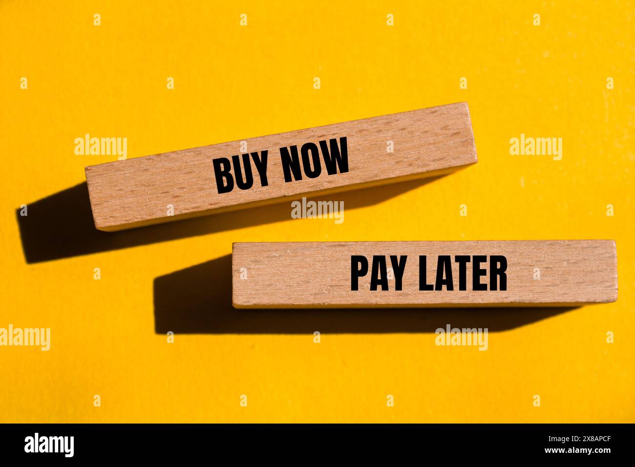 Acheter maintenant payer plus tard mots écrits sur des blocs de bois avec fond jaune. Symbole conceptuel acheter maintenant payer plus tard. Copier l'espace. Banque D'Images