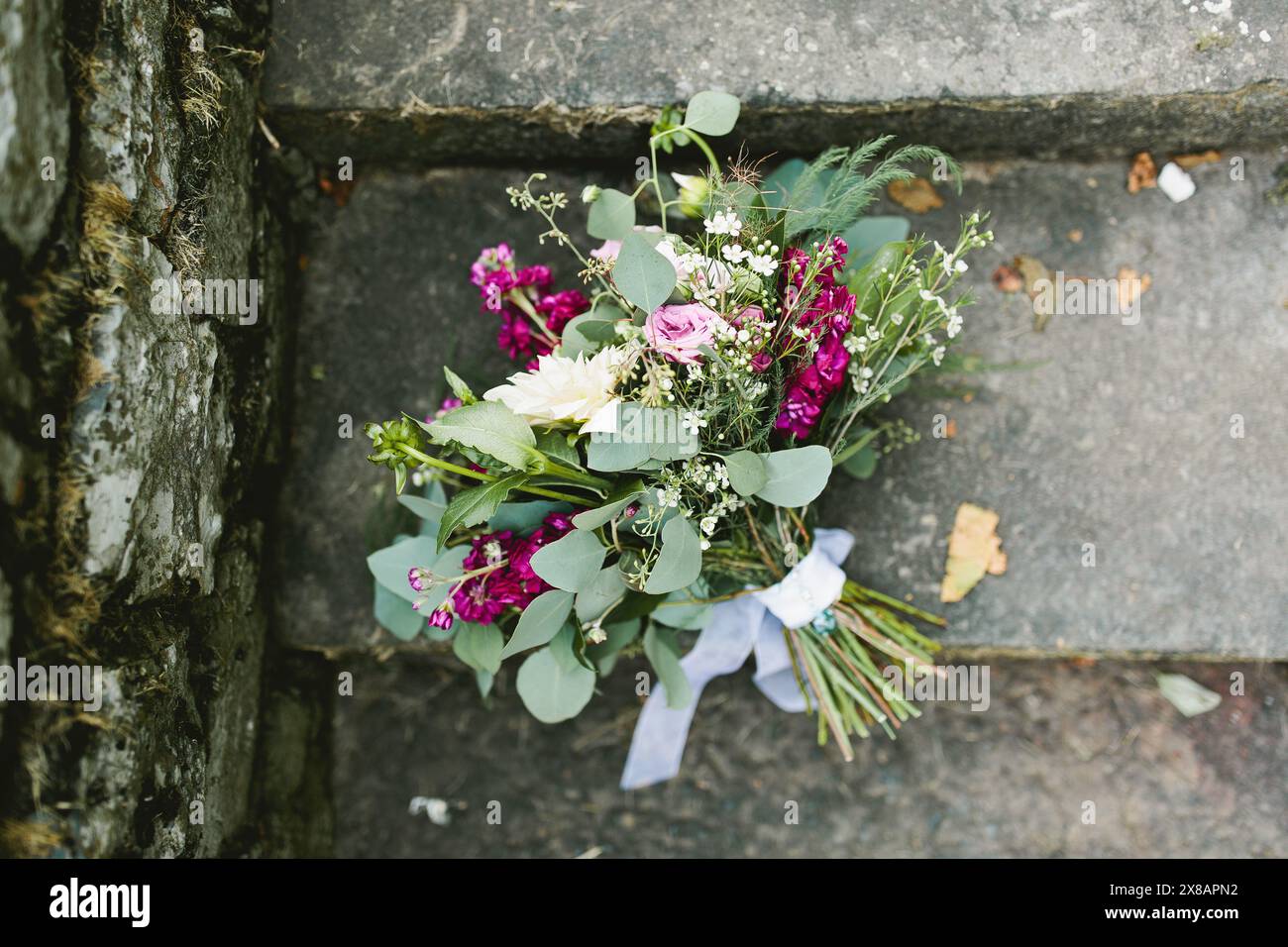 Le bouquet de mariée de mariage repose sur des marches en pierre avec des fleurs roses Banque D'Images
