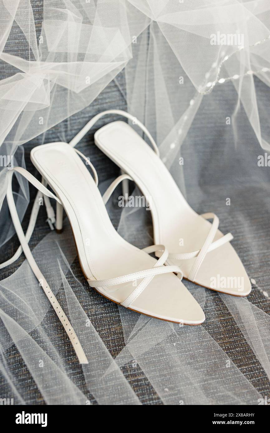 Chaussures de mariée blanches sur un voile de tulle Banque D'Images