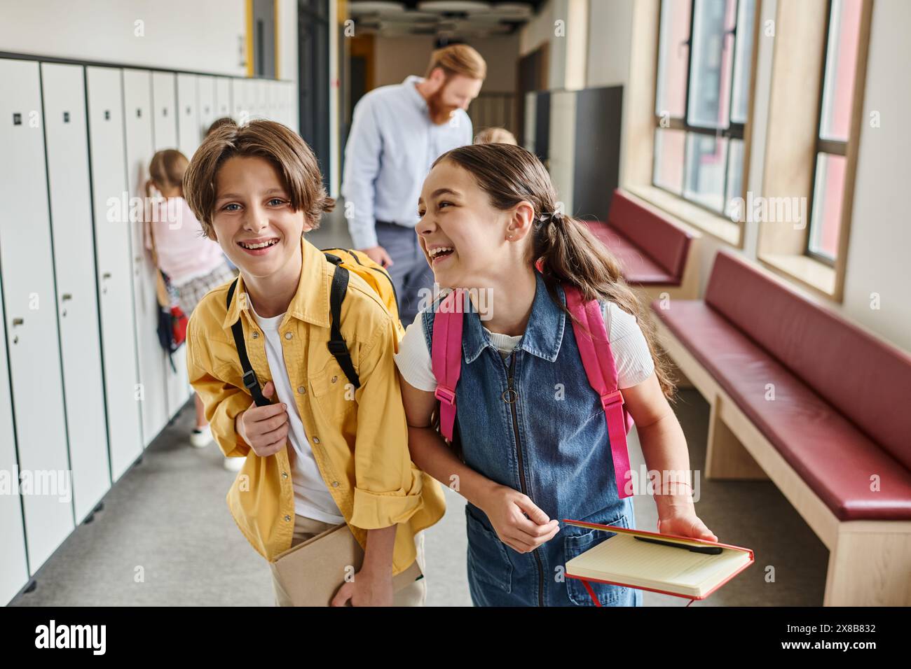 Une paire d'enfants se promenant dans un couloir bordé de casiers, trempant dans les couleurs vibrantes et l'atmosphère unique. Banque D'Images