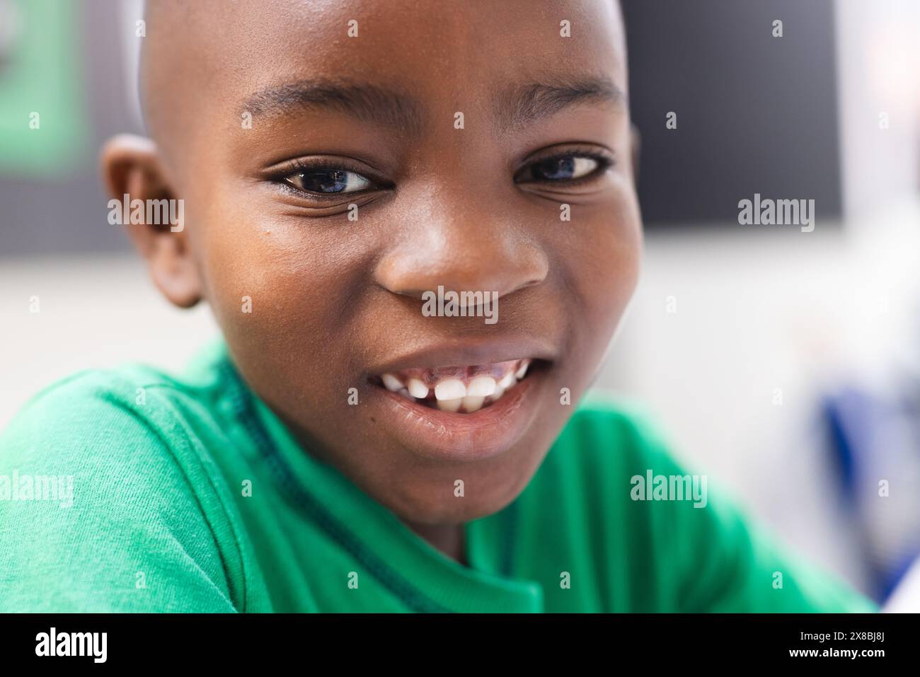 À l'école, un jeune afro-américain sourit à la caméra dans la salle de classe Banque D'Images