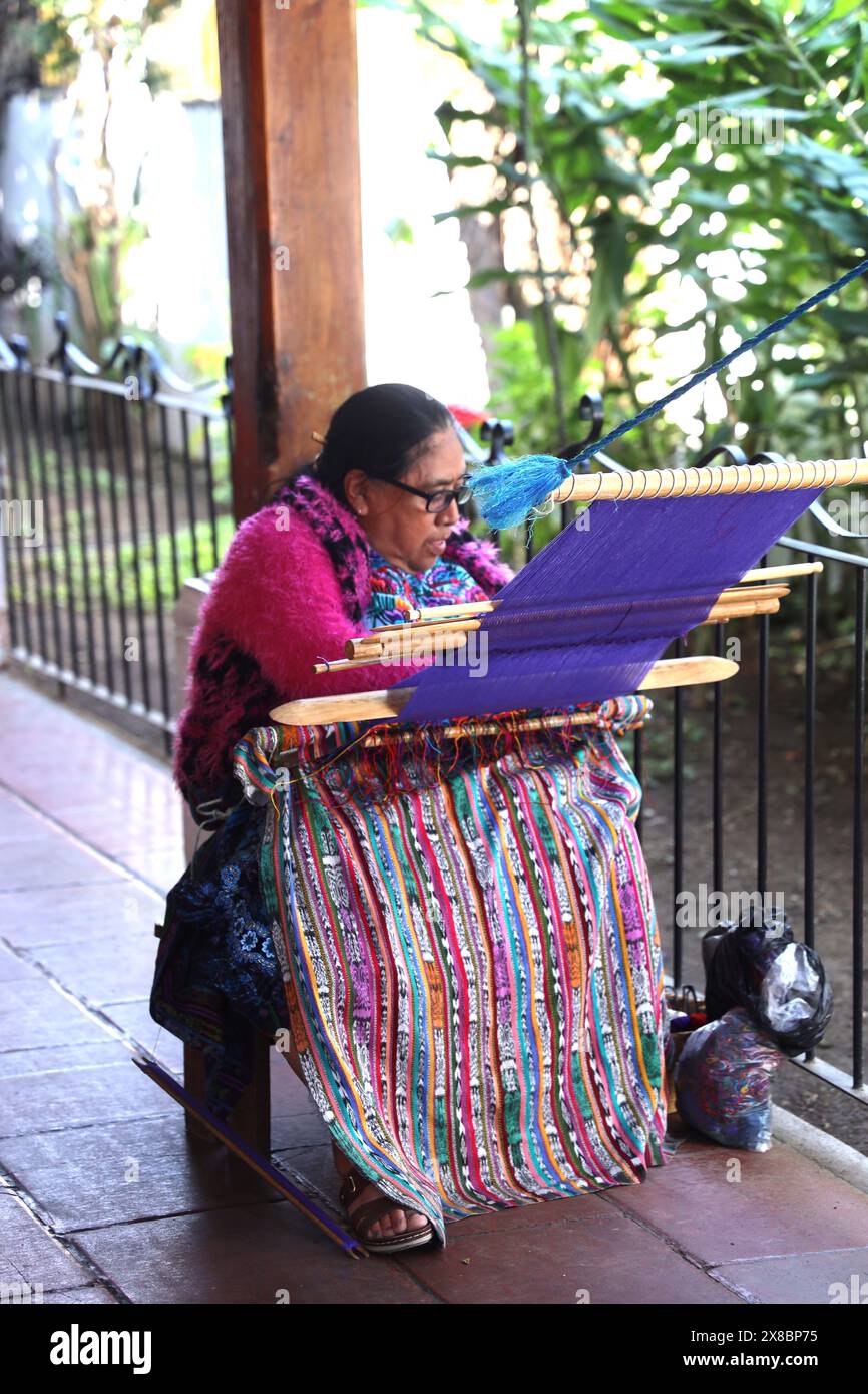 Femme maya indigène utilisant un métier à tisser à sangle arrière pour tisser le tissu. Textiles colorés fabriqués à la main, Antigua. Artesans du Guatemala Amérique centrale. Banque D'Images